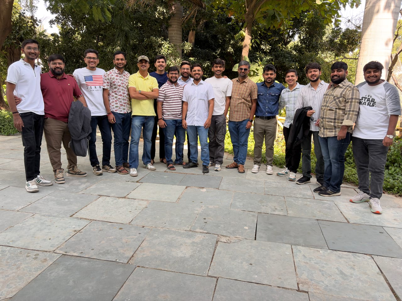 A group photo of the team on a stone path shaded by trees