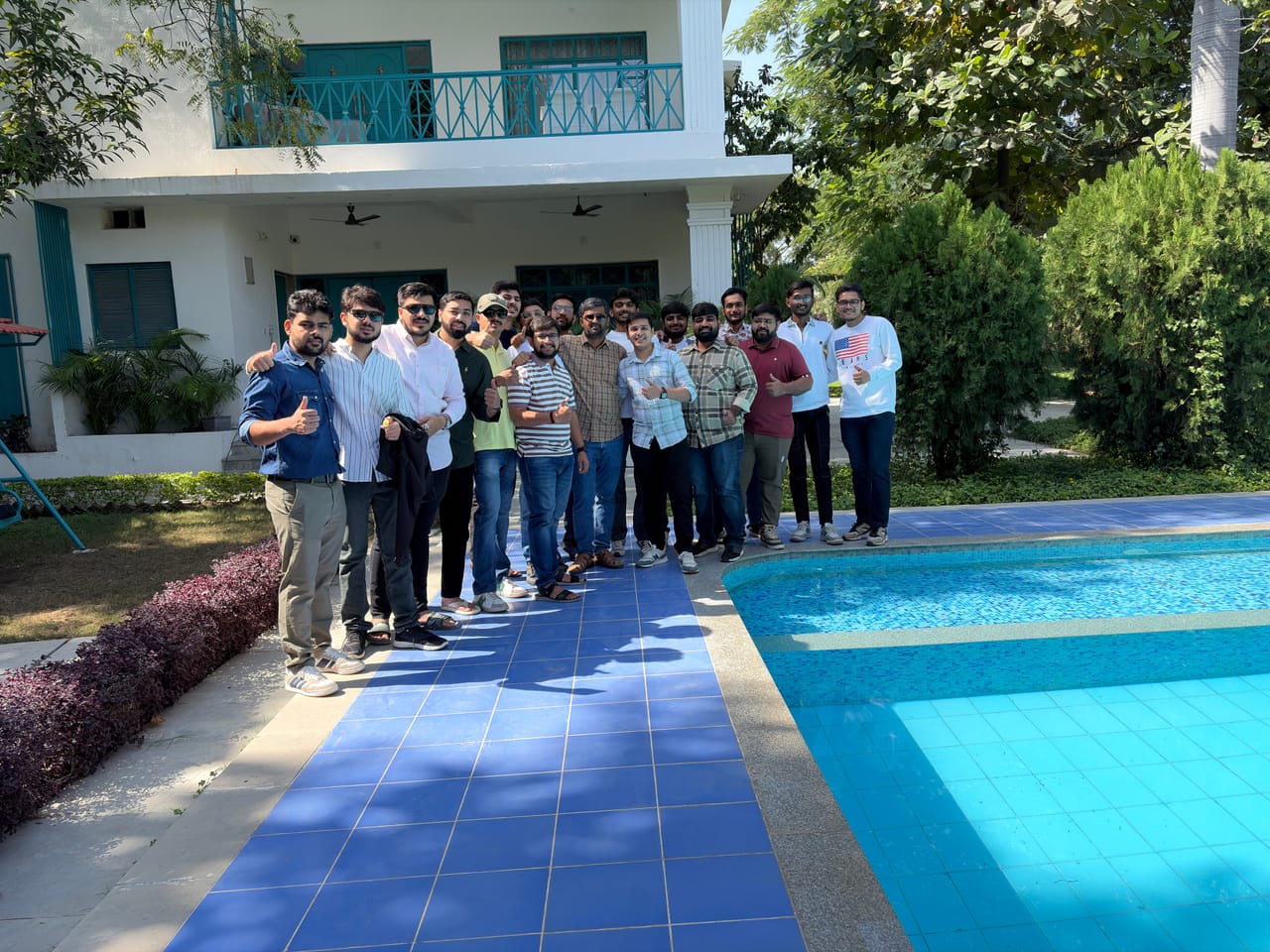 Team members lined up beside the pool at a company offsite