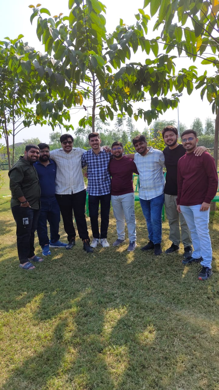 Colleagues standing together under a tree on an outdoor team day