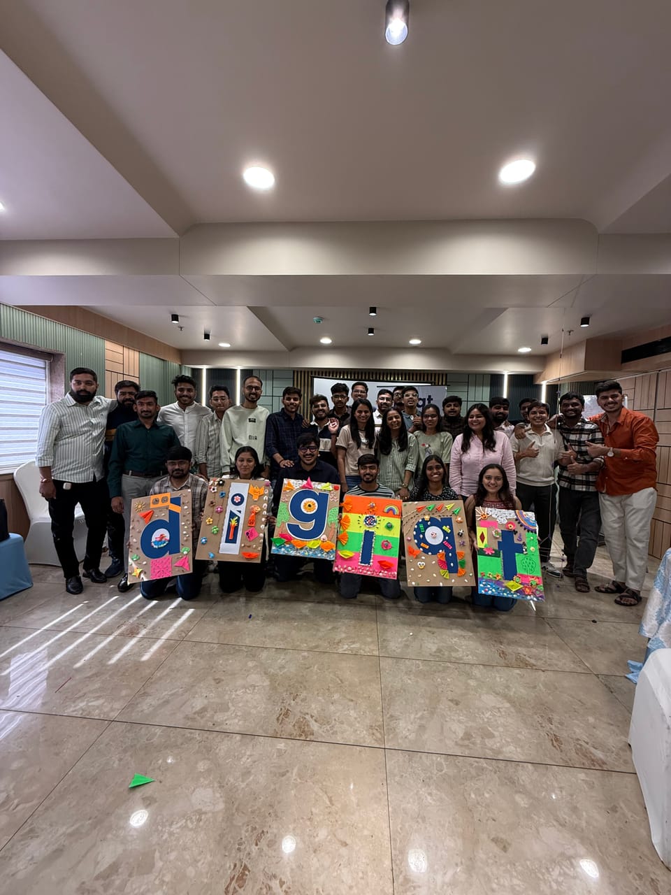The team gathered for a group photo holding hand-painted letter boards