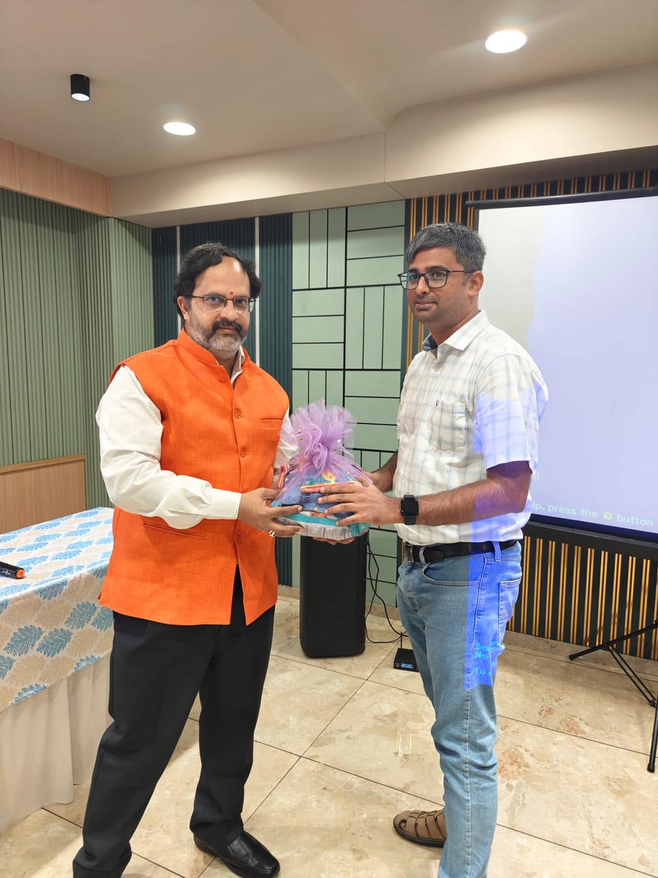 A memento being presented to a guest speaker at an office event