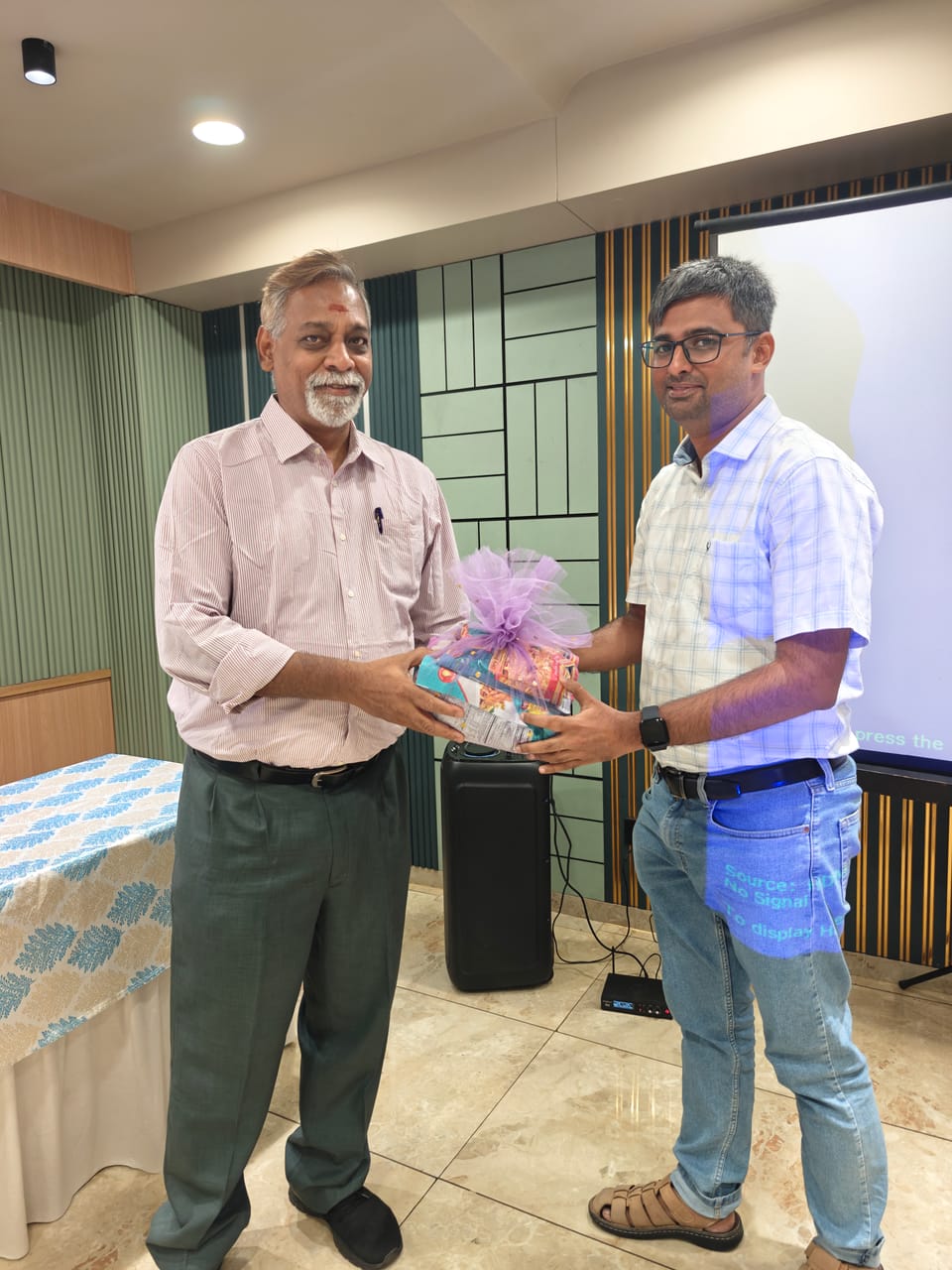 A memento being handed over to a guest at an office event